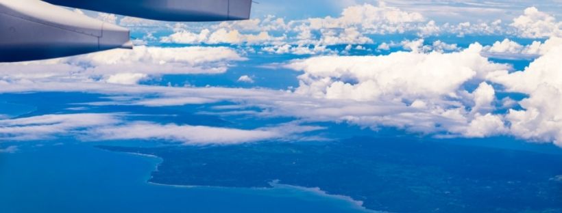 vue d’un avion des nuages et de la côte au loin qui bord la mer