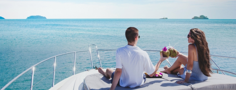 Un homme et une femme assis à l'avant d'un bateau avec cocktail