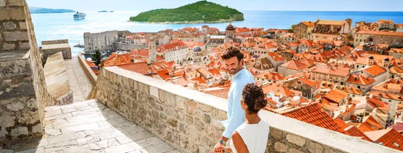 Un couple en italie avec un bateau de croisière au loin