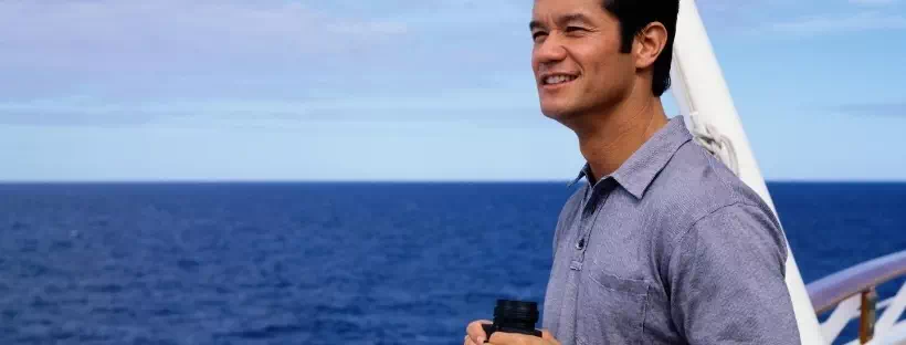 Homme de profil, sur un pont, regardant vers la mer