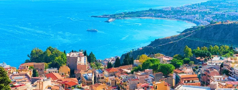 Vue en hauteur sur le bord de mer de Taormine avec habitations