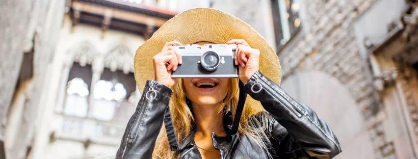 Touriste femme qui sourit et prend en photo quelque chose