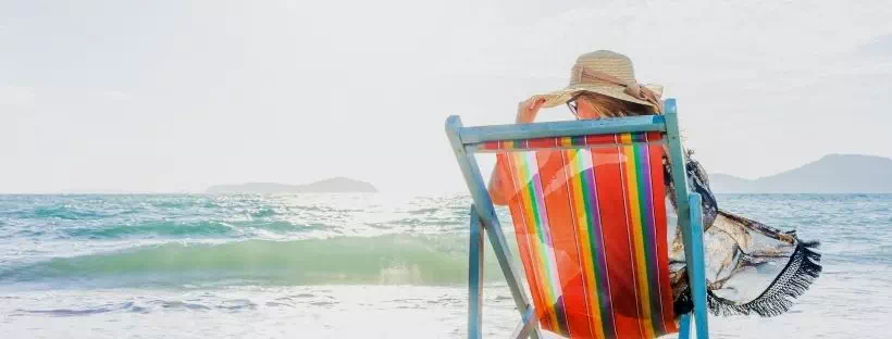 femme sur un transat sur la plage face à la mer